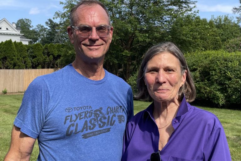 Man and woman in backyard smiling into camera