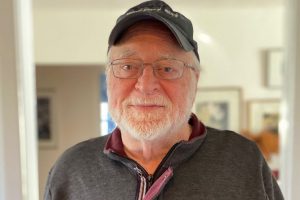 headshot bearded man wearing glasses and hat