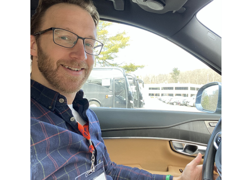 smiling young man volunteer driver in drivers seat