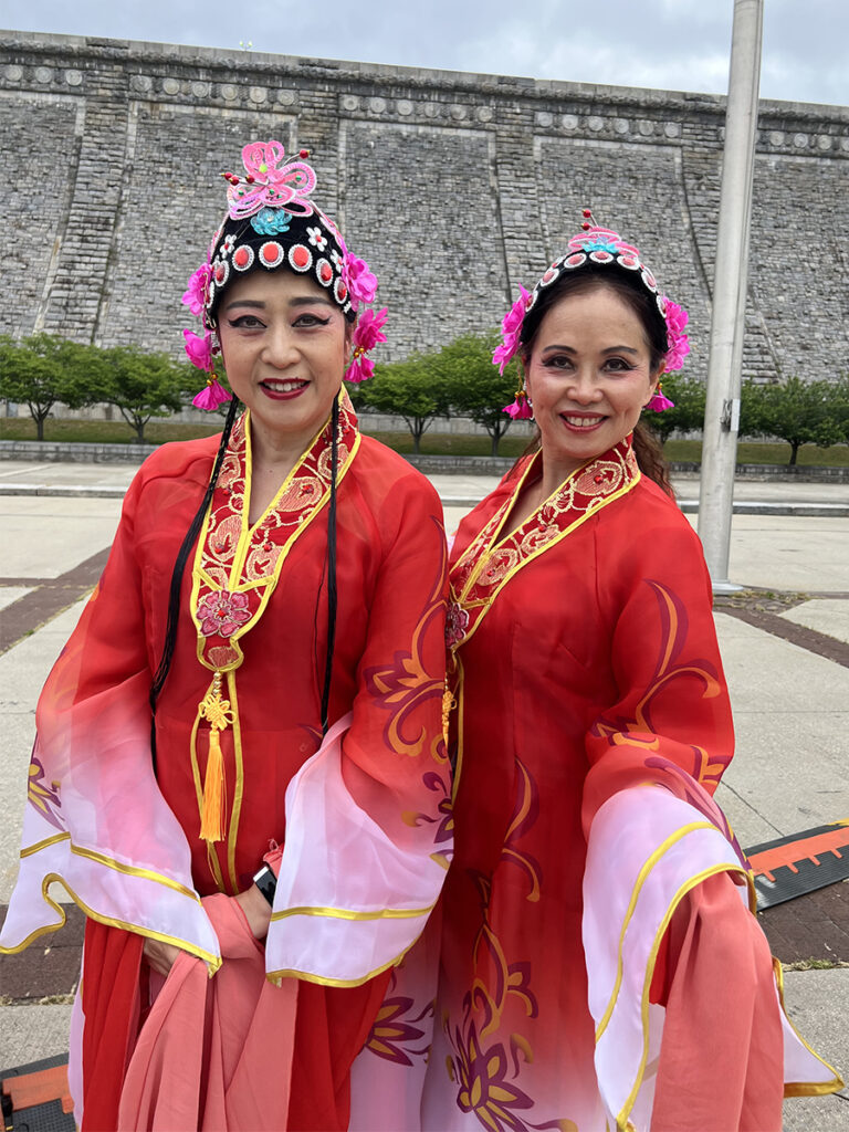 Two Asian American women in red traditional dance dresses 
