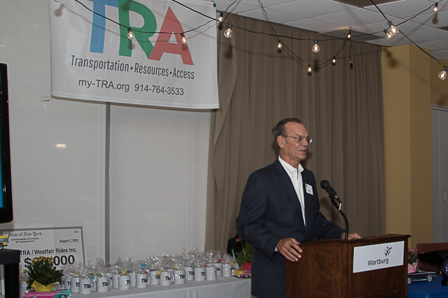 Joe Majsak at podium with TRA banner behind him