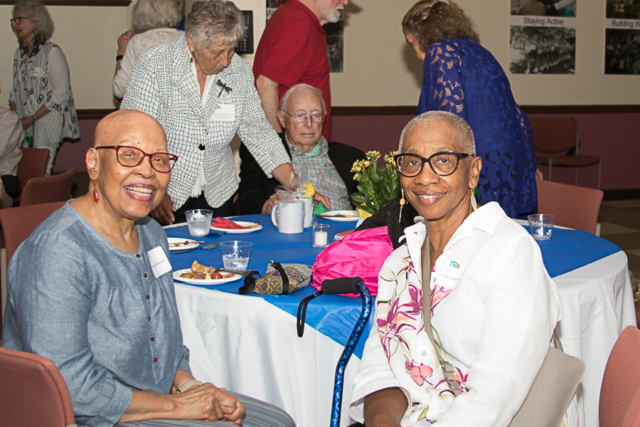 Two women, both wearing glasses, dressed up at event table