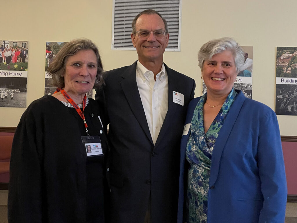 three people at event standing smiling at camera