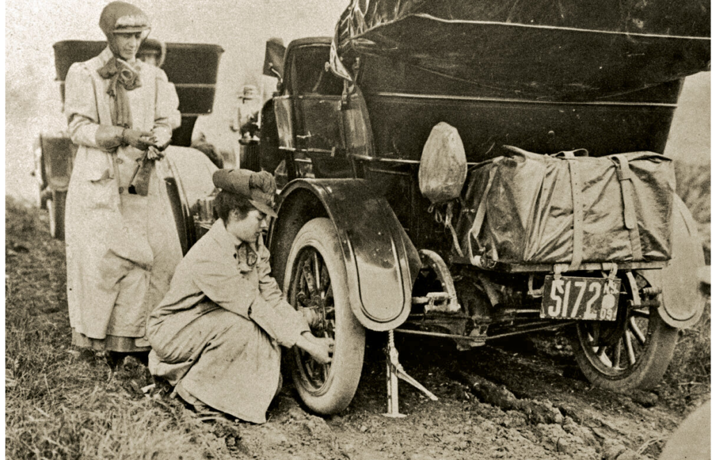 Vintage photo of Alice Ramsey changing a tire on here 1909 cross country drive