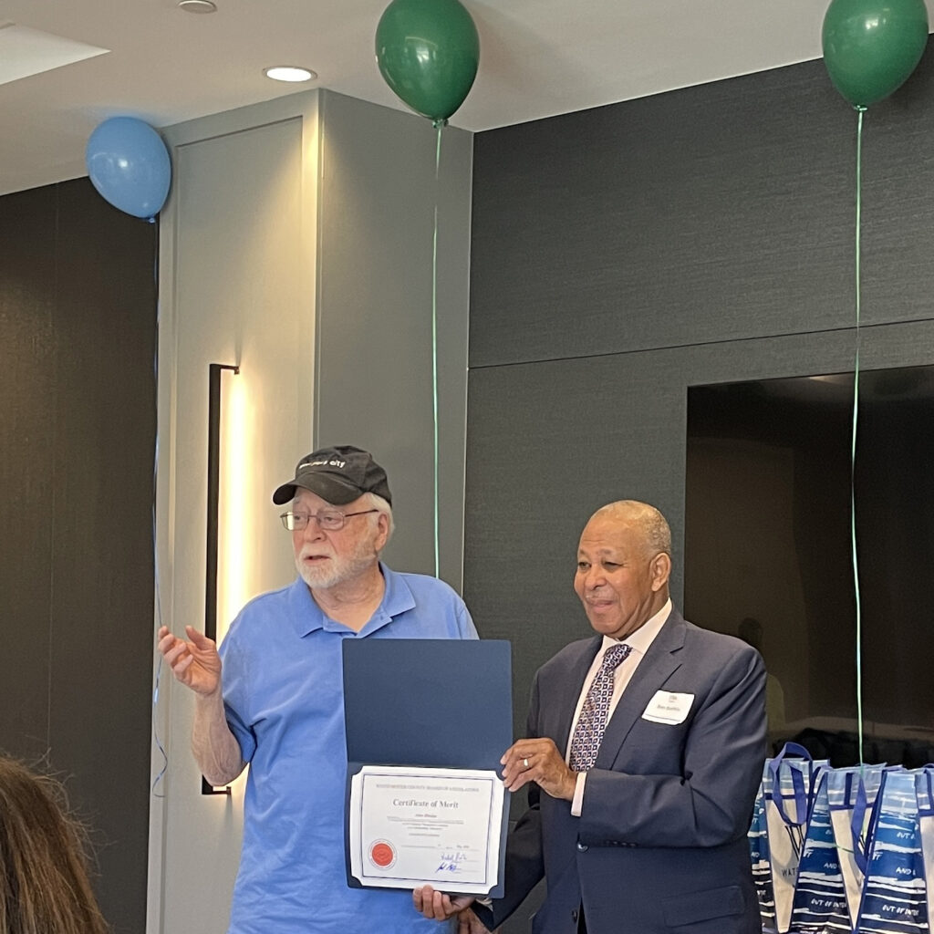Volunter holds up hand to speak as Legislator Boykin presents certificate of merit