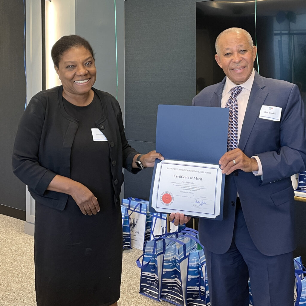 Legislator Boykin presents certificate of merit to smiling volunteer in black dress