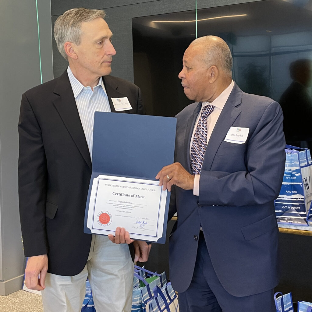 Legislator Boykin presents certificate to volunteer as they look directly at each other