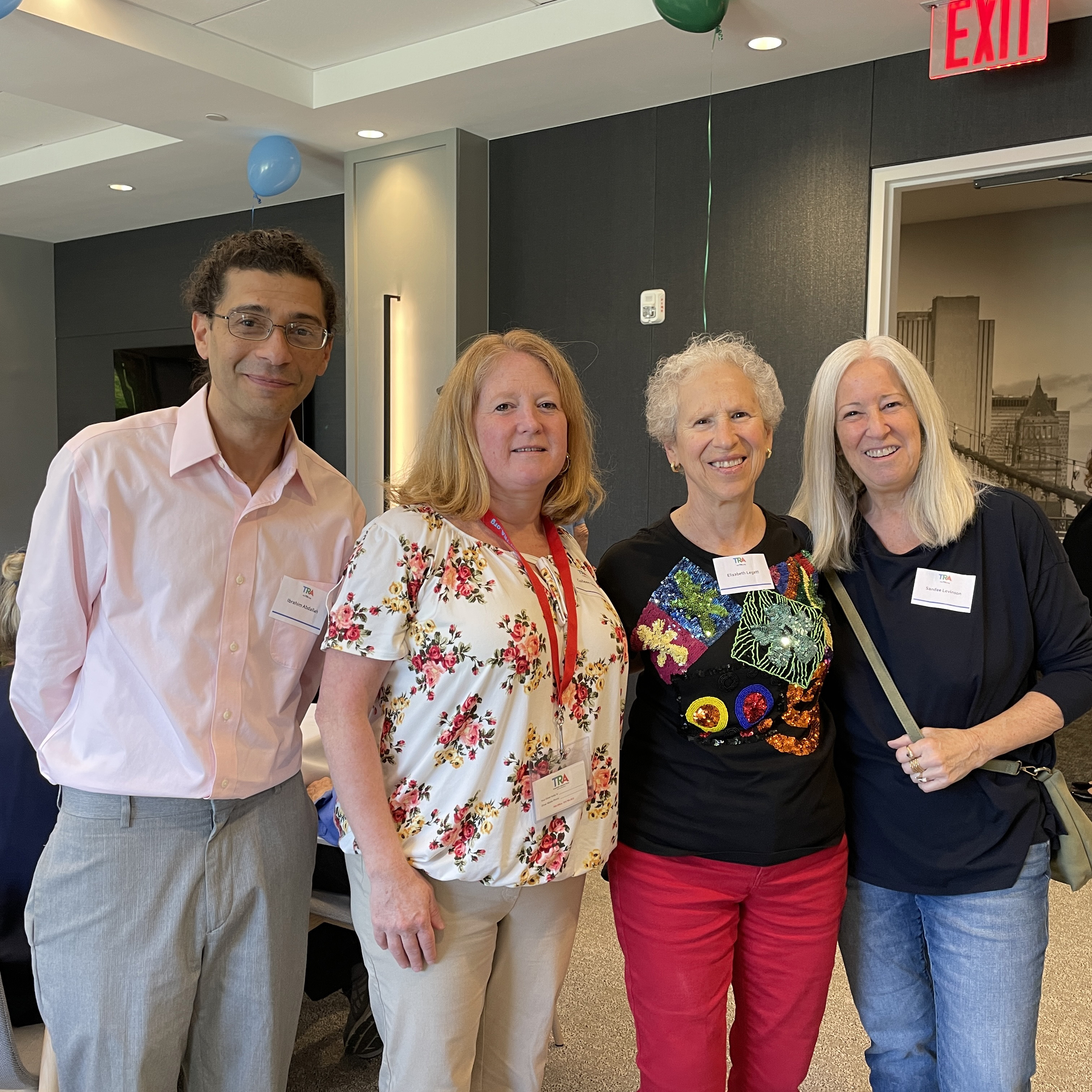 Two staff members stand with two volunteers
