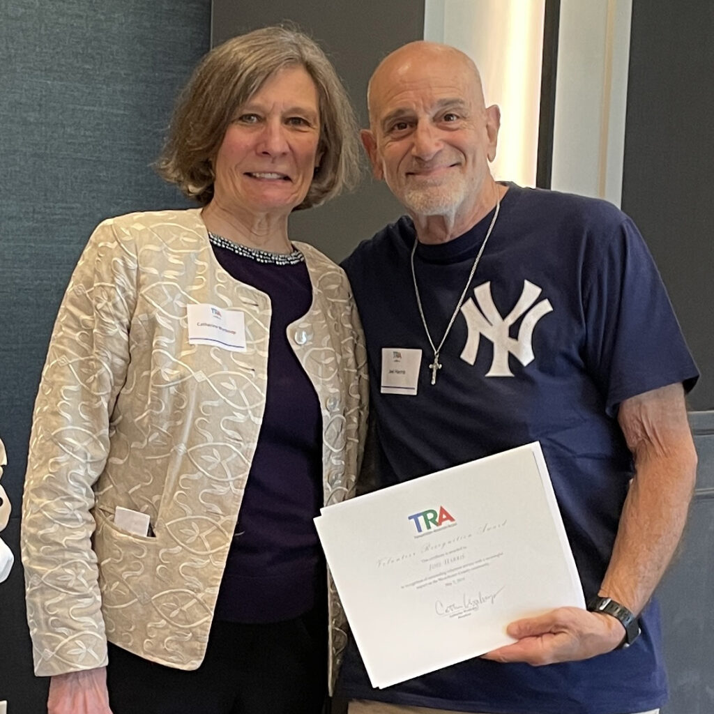 Smiling TRA President gives certificate to smiling volunteer driver wearing Yankee shirt