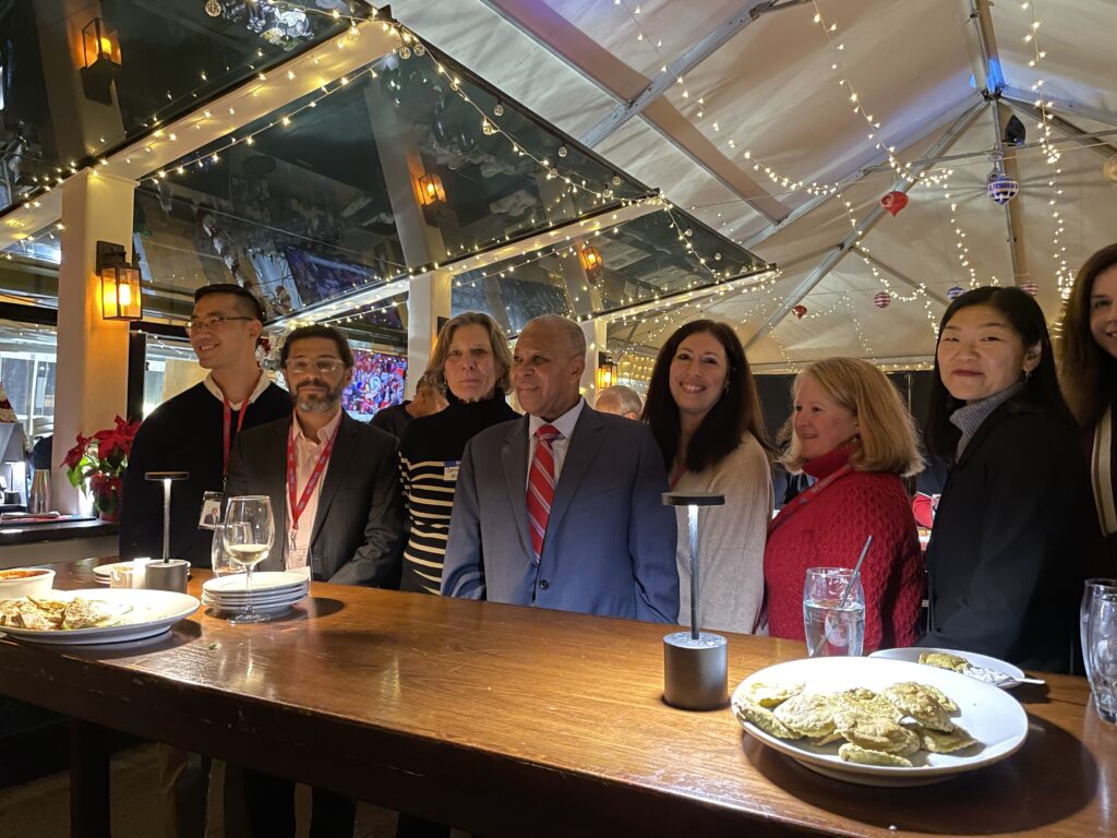 Seven adults lined up behind a tall table