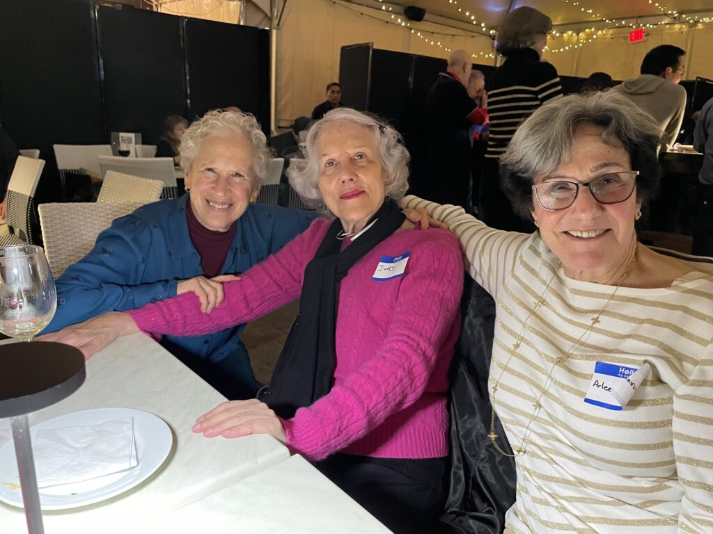 Three women all volunteers smiling for picture