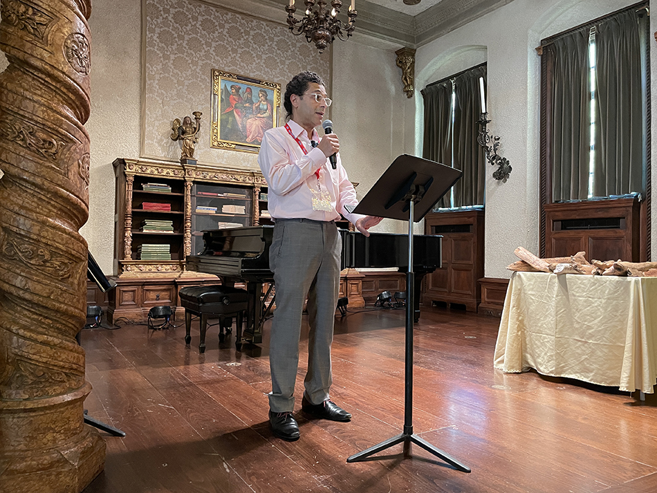 Man stands on elegant stage speaking to audience