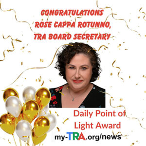 headshot of smiling woman with black curly hair, confetti and balloons