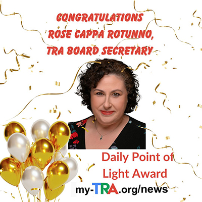 headshot of smiling woman with black curly hair, confetti and balloons