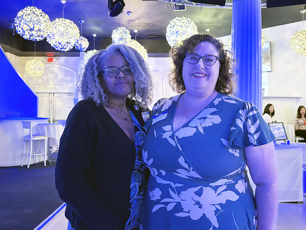 two women standing for a photo with restaurant decor in background