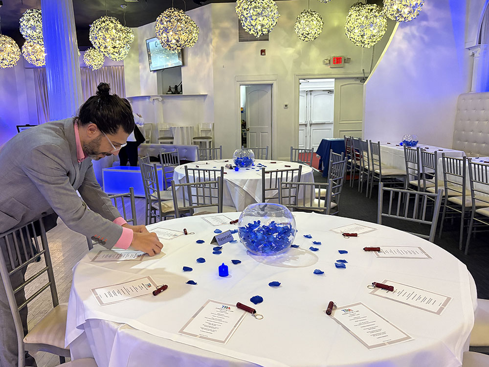 Man in suit adding decorations to dining table
