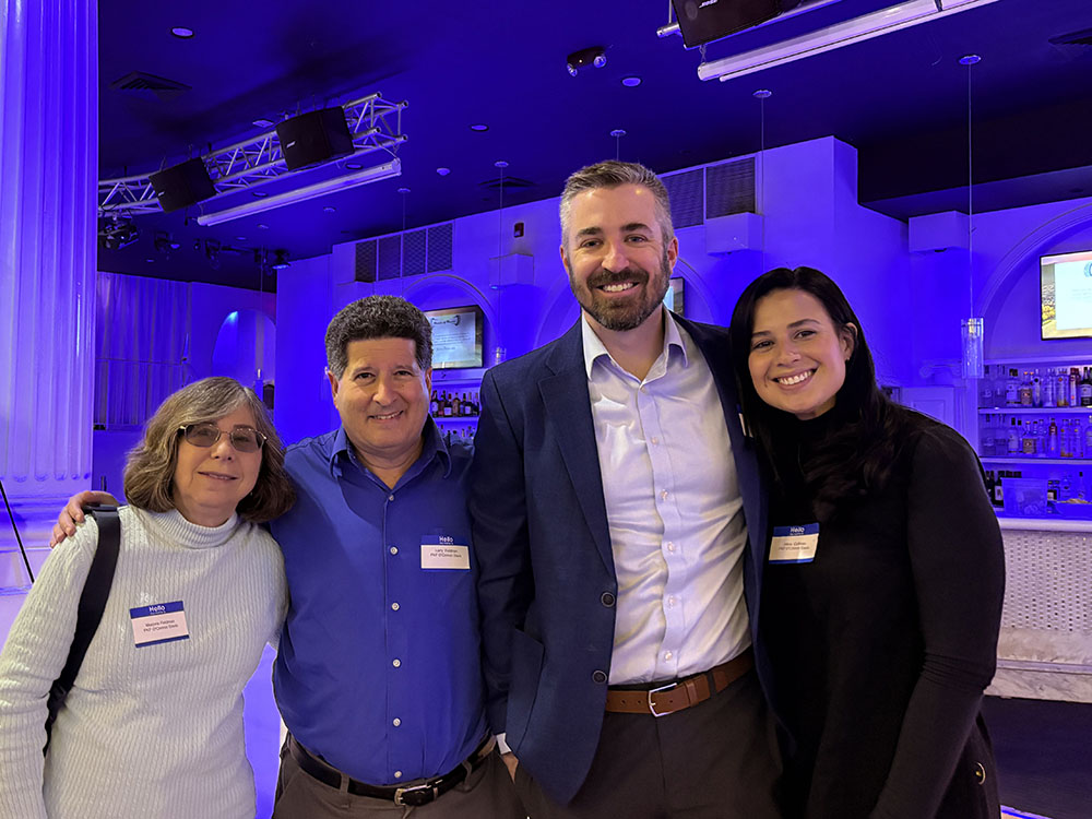 group of four work colleagues stand for a photo