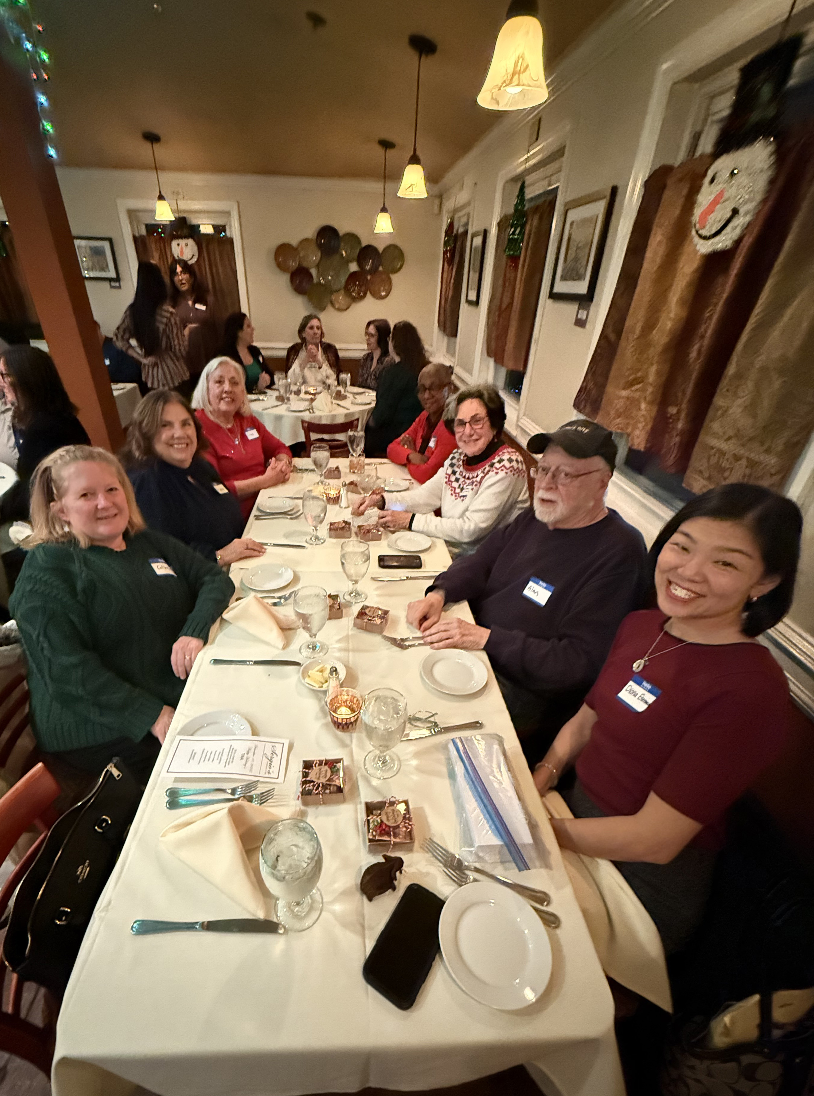 guests sit at long table for photo at volunteet winter luncheon