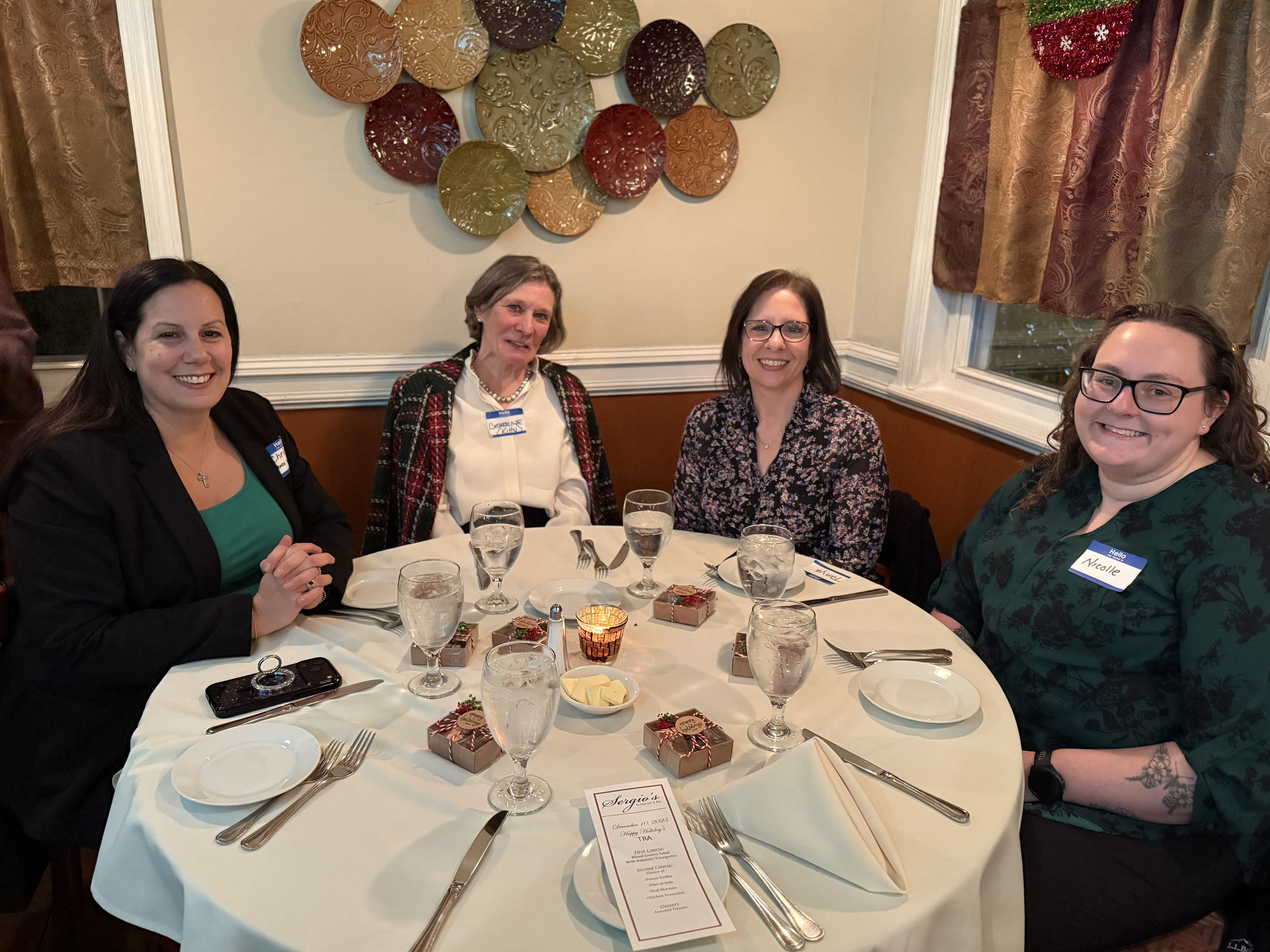four women site at festive volunteer winter luncheon table.